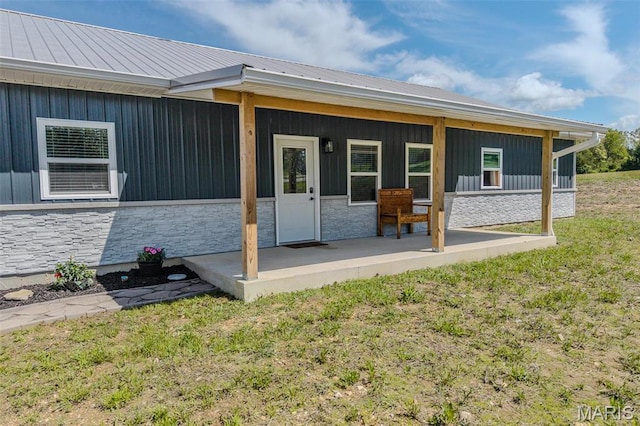 22950 Pin Oak Dr, Lebanon, MO 65536 - doorway to property featuring stone siding, a yard, metal roof, board and batten siding, and a porch