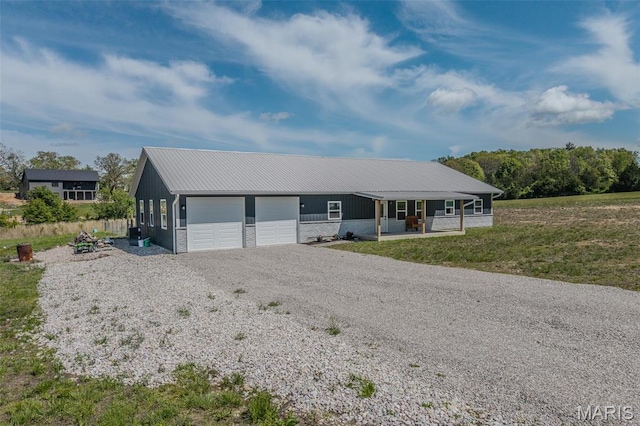 22950 Pin Oak Dr, Lebanon, MO 65536 - ranch-style house with an attached garage, gravel driveway, a porch, and metal roof