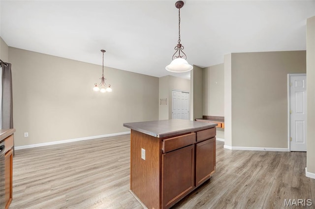 554 Springhurst Pkwy, Ofallon, MO 63368 - kitchen with light wood finished floors, a chandelier, baseboards, and a kitchen island