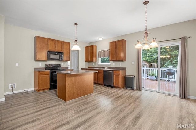 554 Springhurst Pkwy, Ofallon, MO 63368 - kitchen featuring black appliances, light wood finished floors, brown cabinets, and healthy amount of natural light