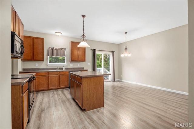 554 Springhurst Pkwy, Ofallon, MO 63368 - kitchen featuring black appliances, light wood-style floors, a sink, a center island, and brown cabinetry