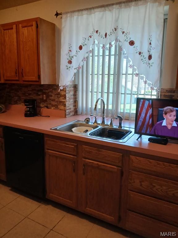 10506 Camden Park Dr, Saint Louis, MO 63135 - kitchen featuring black dishwasher, a sink, light tile patterned floors, and light countertops