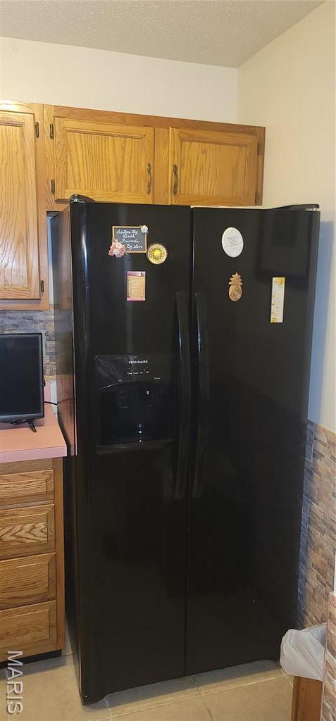10506 Camden Park Dr, Saint Louis, MO 63135 - kitchen featuring black refrigerator with ice dispenser and brown cabinetry