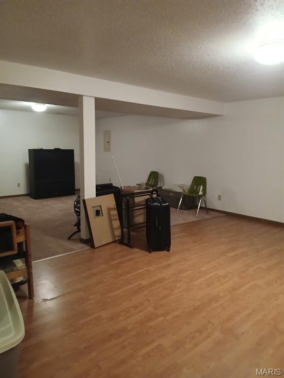 10506 Camden Park Dr, Saint Louis, MO 63135 - finished basement with light wood finished floors and a textured ceiling