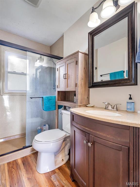 1101 Sunset Dr, Sullivan, MO 63080 - full bathroom with a stall shower, toilet, vanity, and wood finished floors