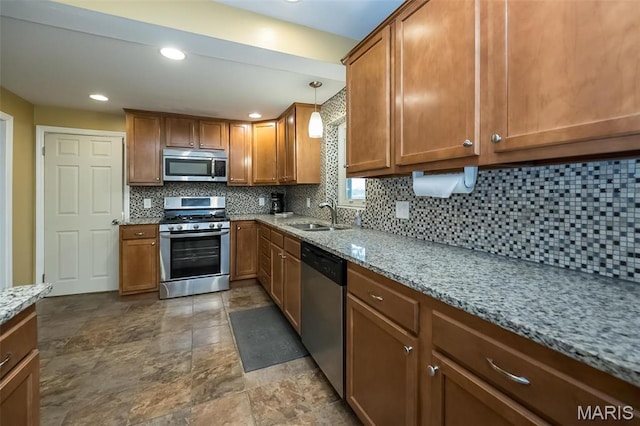 126 E Waymire Ave, Saint Louis, MO 63119 - kitchen featuring stainless steel appliances, a sink, brown cabinets, light stone counters, and recessed lighting