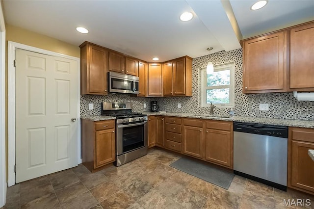 126 E Waymire Ave, Saint Louis, MO 63119 - kitchen featuring appliances with stainless steel finishes, a sink, decorative backsplash, light stone counters, and brown cabinetry