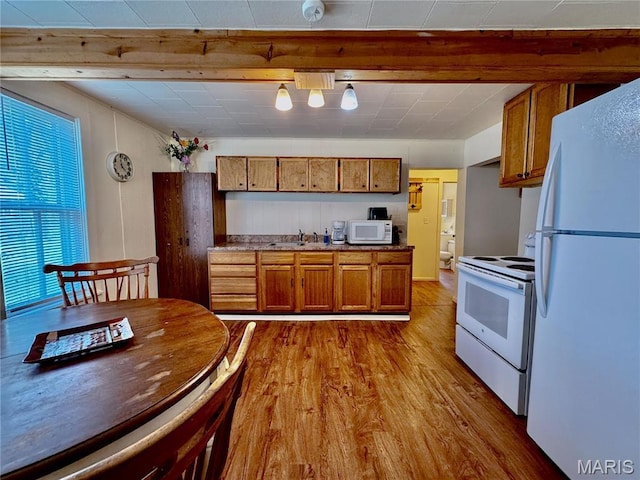 274 Cornelison St, Lebanon, MO 65536 - kitchen with white appliances, brown cabinetry, a sink, wood finished floors, and beamed ceiling