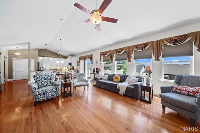 living room featuring vaulted ceiling, light wood-type flooring, and ceiling fan