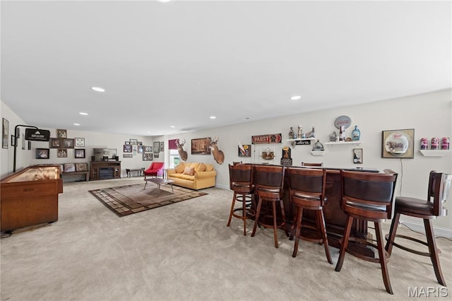dining space featuring a bar, carpet floors, recessed lighting, and baseboards