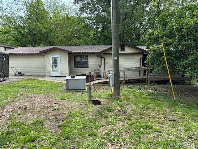 back of house featuring a wooden deck and metal roof