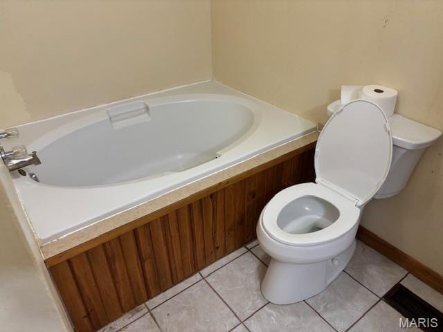 bathroom featuring toilet, a bath, and tile patterned flooring