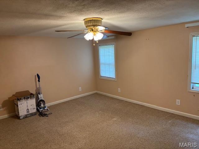 unfurnished room featuring ceiling fan, carpet flooring, baseboards, and a textured ceiling