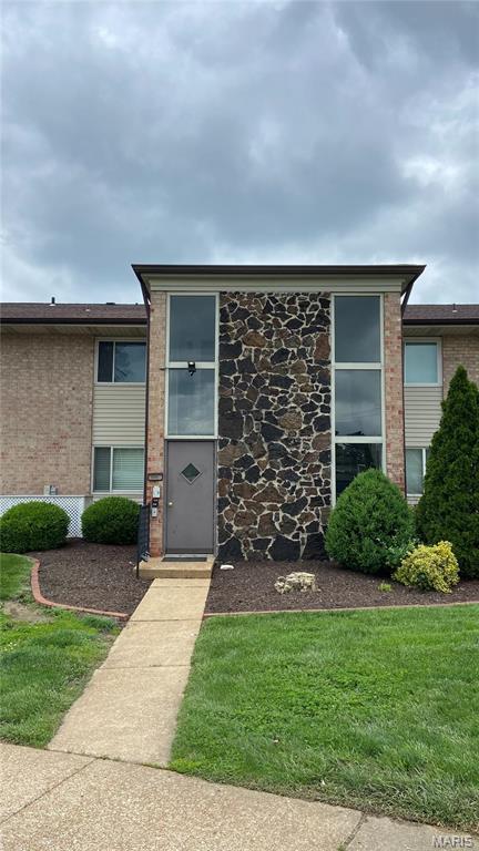 view of front facade featuring brick siding and a front yard
