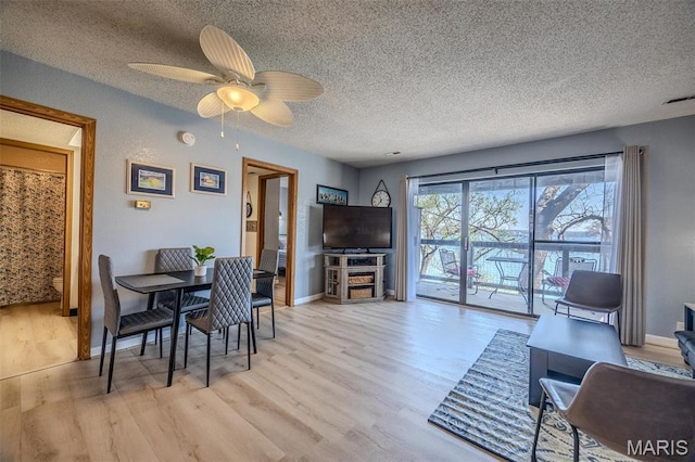 256 Lone Oak Unit 15, Sunrise Beach, MO 65079 - dining space featuring a textured ceiling, light wood-style floors, ceiling fan, and baseboards