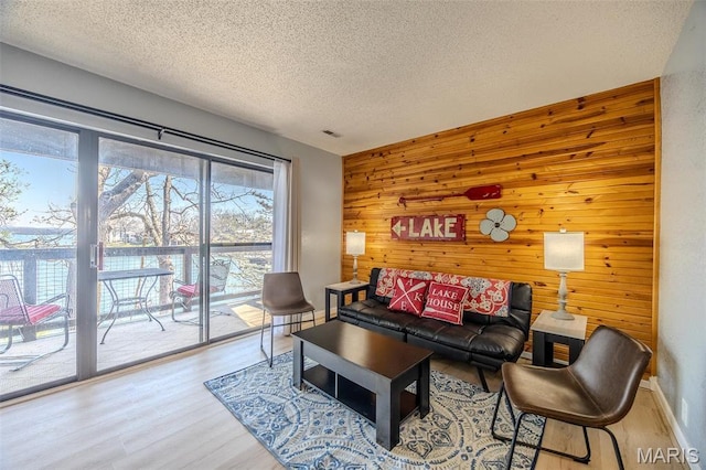 256 Lone Oak Unit 15, Sunrise Beach, MO 65079 - living area with wooden walls, a textured ceiling, wood finished floors, and an accent wall