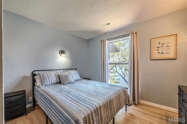 256 Lone Oak Unit 15, Sunrise Beach, MO 65079 - bedroom featuring light wood-style flooring, baseboards, and a textured ceiling