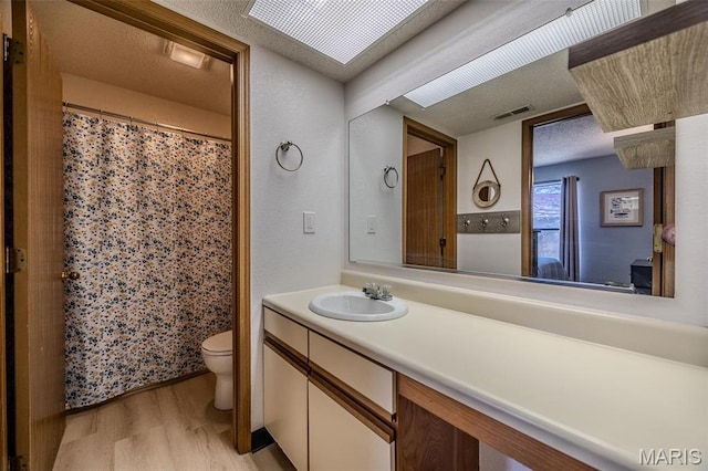 256 Lone Oak Unit 15, Sunrise Beach, MO 65079 - full bathroom featuring wood finished floors, toilet, vanity, and a shower with shower curtain