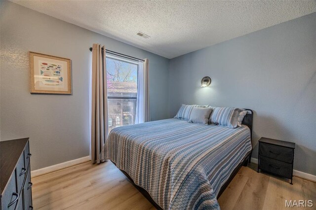 256 Lone Oak Unit 15, Sunrise Beach, MO 65079 - bedroom with light wood finished floors, baseboards, and a textured ceiling