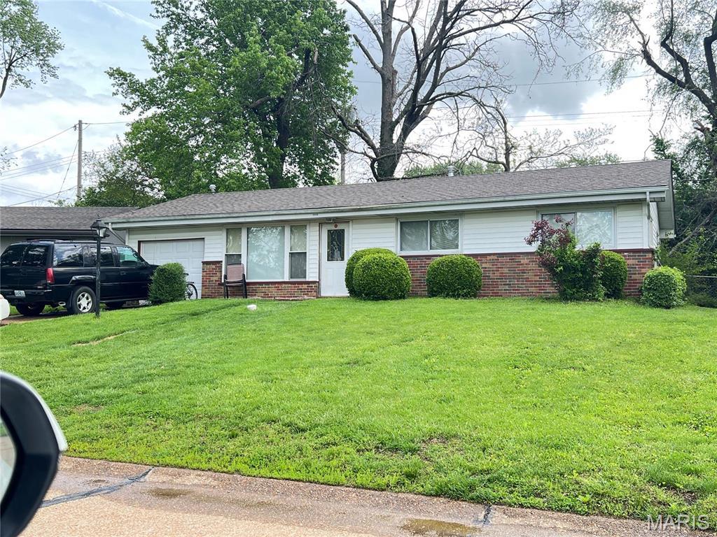 ranch-style house with an attached garage, brick siding, and a front yard