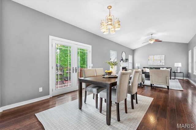 2226 Bay Tree Dr, Saint Peters, MO 63376 - dining space featuring a chandelier, vaulted ceiling, dark wood finished floors, baseboards, and a warm lit fireplace