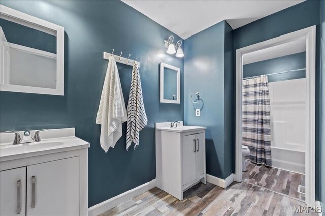 2226 Bay Tree Dr, Saint Peters, MO 63376 - full bath featuring wood finished floors, two vanities, baseboards, and toilet