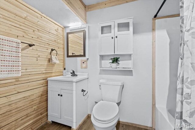 2226 Bay Tree Dr, Saint Peters, MO 63376 - bathroom featuring wood walls, toilet, wood finished floors, vanity, and shower / bath combo with shower curtain