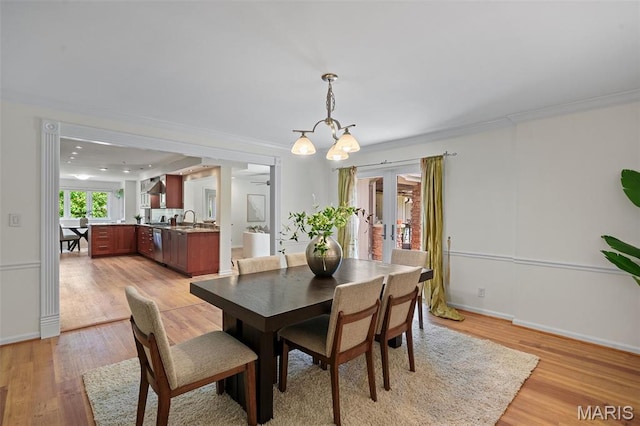 2125 Crystal Dr, Saint Louis, MO 63131 - dining space featuring light wood-style floors, french doors, baseboards, a chandelier, and crown molding