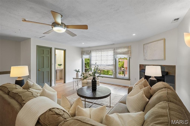 2125 Crystal Dr, Saint Louis, MO 63131 - living room featuring light wood-style flooring, a textured ceiling, a ceiling fan, baseboards, and recessed lighting