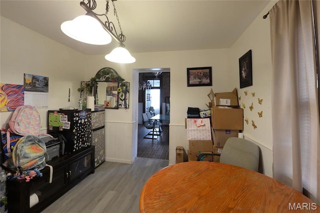 dining area featuring wood finished floors and wainscoting