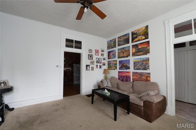 carpeted living room featuring ceiling fan and a textured ceiling