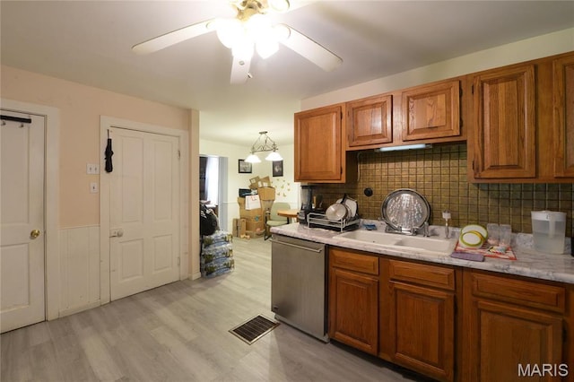 kitchen featuring dishwasher, brown cabinets, ceiling fan, light countertops, and light wood-type flooring