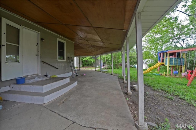 view of patio featuring a playground and a carport