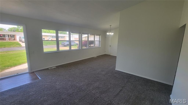 2490 Northridge Pl, Florissant, MO 63033 - empty room with healthy amount of natural light, a chandelier, baseboards, and dark carpet