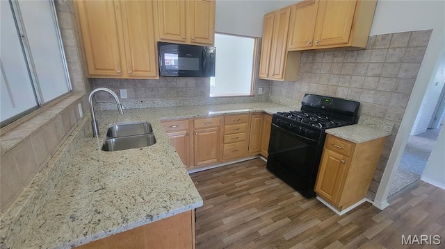 2490 Northridge Pl, Florissant, MO 63033 - kitchen with black appliances, a sink, wood finished floors, and backsplash