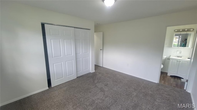 2490 Northridge Pl, Florissant, MO 63033 - unfurnished bedroom with dark colored carpet, a sink, a closet, baseboards, and ensuite bath