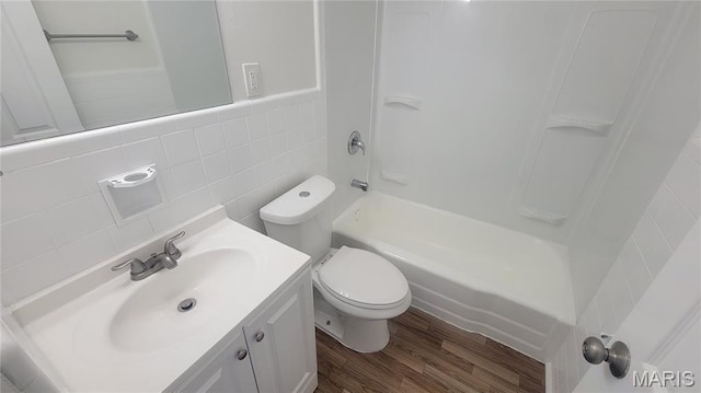 2490 Northridge Pl, Florissant, MO 63033 - full bath with wood finished floors, toilet, tile walls, vanity, and shower / bathtub combination