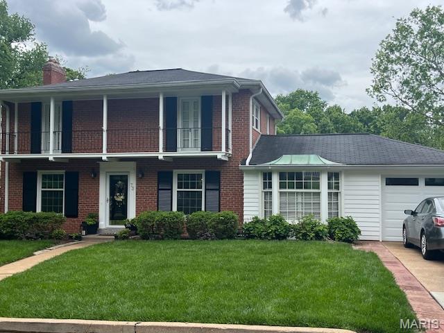 73 Heatherbrook Ln, Saint Louis, MO 63122 - view of front of home featuring a garage, a front yard, a balcony, and a chimney