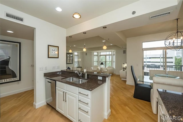kitchen with dishwasher, a sink, light wood-style floors, a peninsula, and open floor plan