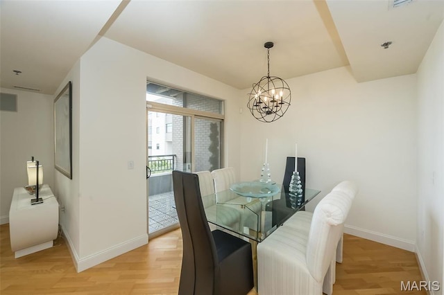 dining area with light wood-style flooring, baseboards, and a chandelier