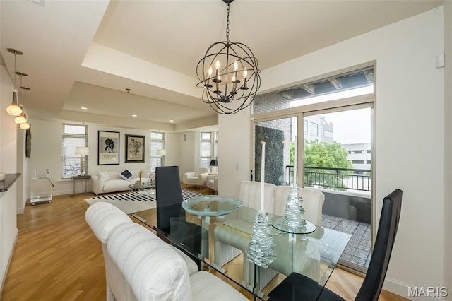 dining room featuring a chandelier, wood finished floors, plenty of natural light, and baseboards