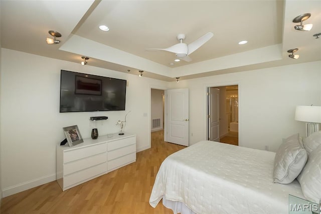 bedroom with a raised ceiling, light wood-type flooring, baseboards, recessed lighting, and ceiling fan