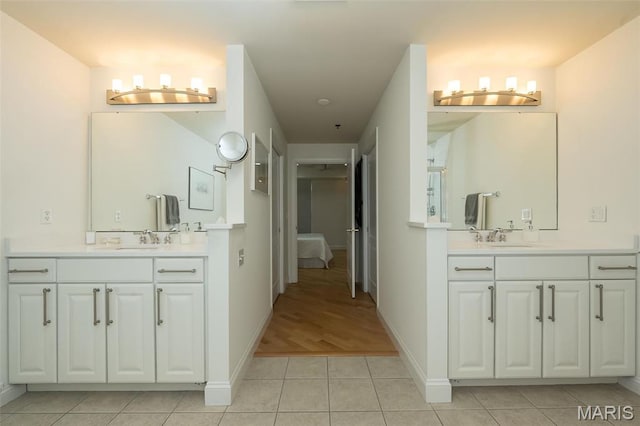 full bathroom with tile patterned floors, two vanities, connected bathroom, and baseboards
