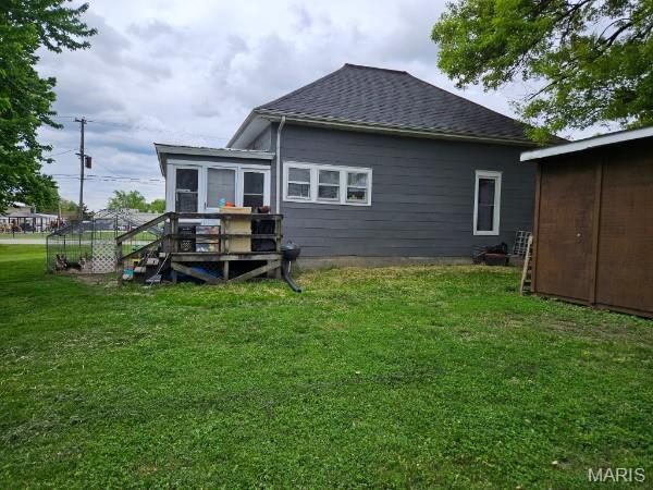 312 S Locust St, Monroe City, MO 63456 - rear view of house with roof with shingles, a lawn, and a wooden deck