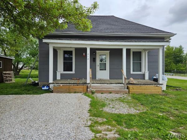 312 S Locust St, Monroe City, MO 63456 - bungalow with roof with shingles, a porch, and a front lawn