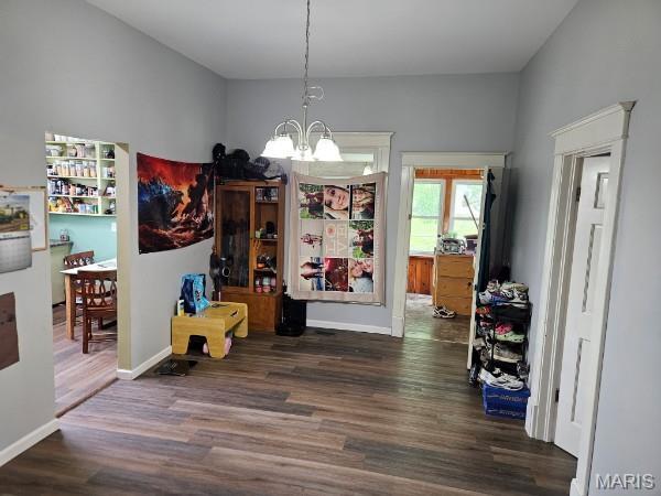 312 S Locust St, Monroe City, MO 63456 - dining room with wood finished floors, a chandelier, and baseboards