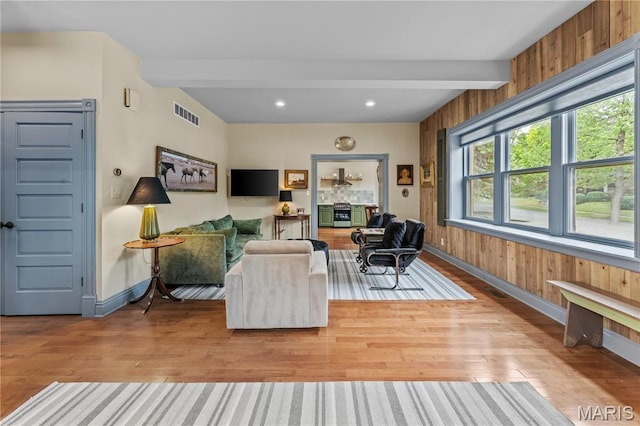 3559 Halliday Ave Unit 102, Saint Louis, MO 63118 - living room with beamed ceiling, healthy amount of natural light, wood finished floors, baseboards, and wood walls