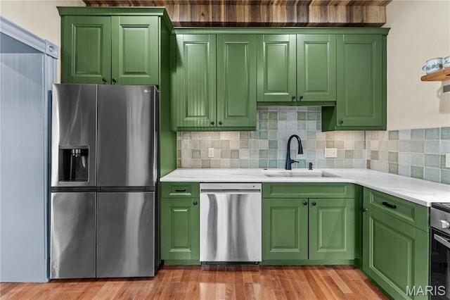 3559 Halliday Ave Unit 102, Saint Louis, MO 63118 - kitchen featuring appliances with stainless steel finishes, a sink, green cabinetry, light countertops, and tasteful backsplash