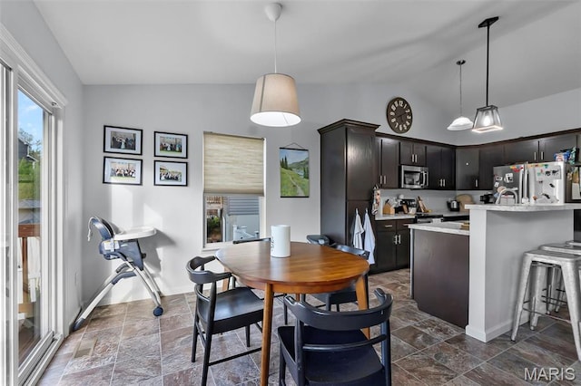 111 Hammond Dr, Herculaneum, MO 63048 - kitchen with vaulted ceiling, appliances with stainless steel finishes, light countertops, dark stone finish floors, and pendant lighting