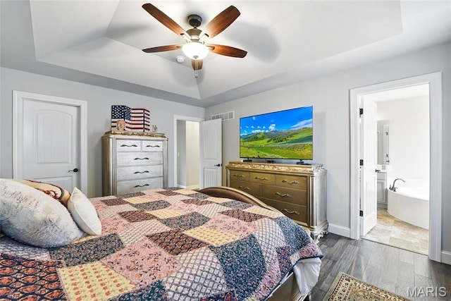 23 Austin Oaks Dr, Moscow Mills, MO 63362 - bedroom featuring a tray ceiling, wood finished floors, a ceiling fan, and ensuite bath